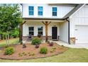 Inviting front porch with seating and landscaped garden, leading to the entrance of this lovely home at 165 Brookstone E Park, Acworth, GA 30101