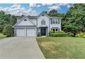 Charming two-story home with a well-manicured lawn, two-car garage, and inviting entrance at 3668 Burel Mill Dr, Buford, GA 30519