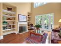 Bright living room featuring tall ceilings, hardwood floors, fireplace with decorative shelves and French doors to deck at 1203 Glenridge Ne Pl, Atlanta, GA 30342