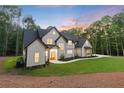 Charming modern farmhouse with black trim surrounded by lush greenery and a large yard at 5567 Tyree Rd, Winston, GA 30187