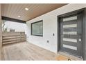 Cozy front porch with wood flooring, a modern black door, and a view of the surrounding landscape at 1355 Lockwood Sw Dr, Atlanta, GA 30311