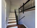 Bright entryway with wood stairs and a dark railing leading to the upper level at 3796 Leesburg Sw Ct, Atlanta, GA 30331