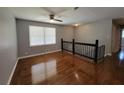 Loft area with hardwood floors, a ceiling fan, and a staircase with a modern railing at 3796 Leesburg Sw Ct, Atlanta, GA 30331