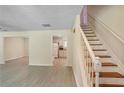 View of the spacious living room, staircase, and kitchen featuring neutral walls and wood look floors at 1284 Brandl Dr., Marietta, GA 30008
