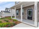 Charming home features a covered front porch with brick facade, white pillars, and black front door at 1640 Tide Mill Rd, Cumming, GA 30040