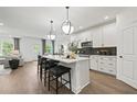 Modern kitchen with white cabinets, a center island with seating, and stainless steel appliances at 1640 Tide Mill Rd, Cumming, GA 30040