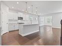 Modern kitchen features a central island, stainless steel appliances, and bright white cabinetry at 1640 Tide Mill Rd, Cumming, GA 30040