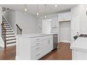Kitchen island has stainless appliances, a double sink and hardwood floors in an open concept kitchen at 1640 Tide Mill Rd, Cumming, GA 30040