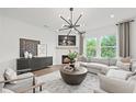 Cozy living room with a fireplace, large windows, and a comfortable gray sofa at 1640 Tide Mill Rd, Cumming, GA 30040