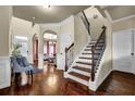 Spacious foyer featuring hardwood floors, staircase with iron balusters, and an arched doorway leading to the living room at 4581 Sagebrush Ct, Snellville, GA 30039