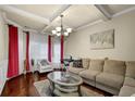 Inviting living room with hardwood floors, tray ceilings, elegant chandelier, and comfortable seating arrangement at 4581 Sagebrush Ct, Snellville, GA 30039