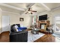 Cozy living room with hardwood floors, a stone fireplace, and a ceiling fan for added comfort at 4581 Sagebrush Ct, Snellville, GA 30039