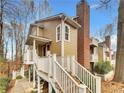 Charming multi-level home featuring upper balconies and a large brick chimney in a wooded area at 2190 River Heights Se Ct, Marietta, GA 30067