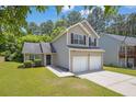 Two-story home with a two-car garage and a green lawn at 3534 Oakshire Se Way, Atlanta, GA 30354