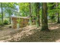 View of home's exterior showing the brick and wood siding in a wooded backyard at 3661 Boring Rd, Decatur, GA 30034