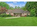 Charming brick home features a manicured lawn, mature trees, and a welcoming entrance for excellent curb appeal at 1275 Fontainebleau Ct, Lawrenceville, GA 30043