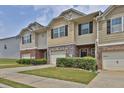 Exterior view of a lovely townhome with a one-car garage and attractive landscaping at 2003 Burns View Ln # 2, Lawrenceville, GA 30044