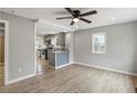 Living room with gray walls, wood floors, and ceiling fan opens to kitchen at 2309 Carver Nw Dr, Atlanta, GA 30314