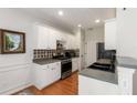Well-lit kitchen with white cabinets, stainless steel appliances, and modern backsplash at 3626 Lantern Crest Cv, Scottdale, GA 30079