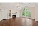 Bright living room boasts a fireplace, built-in shelves, and a large arched window with natural light at 909 Wentworth Ct, Alpharetta, GA 30022