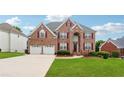 Inviting two-story brick home with attached two-car garage, red shutters and a meticulously maintained lawn at 2372 Wilshire Way, Douglasville, GA 30135