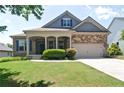 Charming home with a well-manicured lawn, covered porch, and a mix of brick and stone facade at 514 Creekshire Cir, Canton, GA 30115