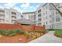 Exterior view of The Prescott luxury condominiums with brick signage and landscaped grounds at 11 Perimeter E Ctr # 1402, Dunwoody, GA 30346