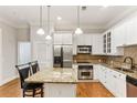 Well-lit kitchen featuring white cabinets, stainless steel appliances, and a granite countertop island at 11 Perimeter E Ctr # 1402, Dunwoody, GA 30346