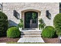 Elegant stone entryway featuring a black double door framed by lush greenery and stylish outdoor lighting at 1191 W Conway Dr, Atlanta, GA 30327