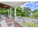 Second story porch with wooden flooring, chairs, white railings, and views of a lush green neighborhood at 1797 Olive Se St, Atlanta, GA 30315