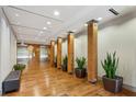 Hallway with wooden pillars, plants, access to elevators, bench, and recessed lighting at 201 W Ponce De Leon Ave # 13, Decatur, GA 30030