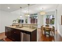 Open floor plan kitchen with granite countertops, stainless steel appliances, and eat-in dining area at 201 W Ponce De Leon Ave # 13, Decatur, GA 30030
