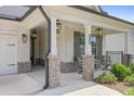Inviting front porch with stone-based columns, black accents, outdoor seating, and manicured landscaping at 419 Southland Cir, Canton, GA 30115