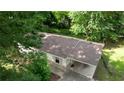 An aerial view of a quaint home, showing the roof, carport, and lush greenery at 50 Woodland St, Buford, GA 30518