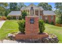 Elegant brick home with landscaped front yard and brick mailbox adorned with a decorative pineapple on a sunny day at 828 Jami Ct, Lawrenceville, GA 30046