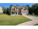 Attractive two-story brick home with a lush green lawn, two-car garage, and tidy landscaping at 953 Mystic Way, Hampton, GA 30228