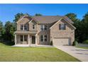 Inviting two-story brick home with a well-kept lawn, two-car garage, and pleasant neighborhood setting at 953 Mystic Way, Hampton, GA 30228