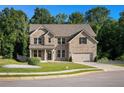 Charming two-story brick home with a manicured lawn, two-car garage, and attractive landscaping at 953 Mystic Way, Hampton, GA 30228