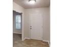 Entryway featuring wood-look flooring and neutral paint, with a view to a windowed room at 2530 Flippen Rd, Stockbridge, GA 30281