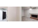 Bright living room with hardwood floors, fireplace, ceiling fan, and an open doorway to the kitchen at 2530 Flippen Rd, Stockbridge, GA 30281