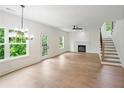 Spacious living room with hardwood floors, lots of natural light, a fireplace and adjacent staircase at 2732 Eagles Crest Ln, Decatur, GA 30034