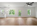 Sun-filled room with hardwood floors, modern chandelier, access to outdoor balcony and views of nature at 2732 Eagles Crest Ln, Decatur, GA 30034