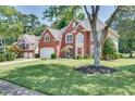 Traditional brick home with attached garage, lush lawn, and mature trees offering a welcoming curb appeal at 3783 Wickford Ln, Peachtree Corners, GA 30096