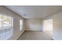 Spacious living room with carpeted floors, neutral paint, and two bright windows at 765 Stonebridge Run, Lithonia, GA 30058