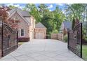 Long concrete driveway leading to a two-car garage behind an ornate gate at 980 Pine Grove Rd, Roswell, GA 30075