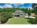 Beautiful two-story home featuring a well-manicured lawn, complemented by mature trees and a detached garage at 102 Cavit Ct, Canton, GA 30114