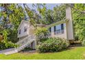 Charming two-story home with a manicured lawn and beautiful landscaping surrounded by trees at 441 Amy Blvd, Temple, GA 30179