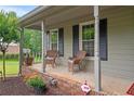 Inviting front porch with cozy seating, brick accents, and views of the landscaped front yard at 9060 Par Dr, Douglasville, GA 30134