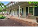 Spacious front porch with brick accents, rocking chairs, and classic columns, perfect for relaxing outdoors at 9060 Par Dr, Douglasville, GA 30134