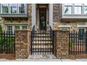 Charming brick and stone home entrance with landscaped steps, black iron fence and trimmed front door at 1120 Cordia Nw Ave, Atlanta, GA 30318